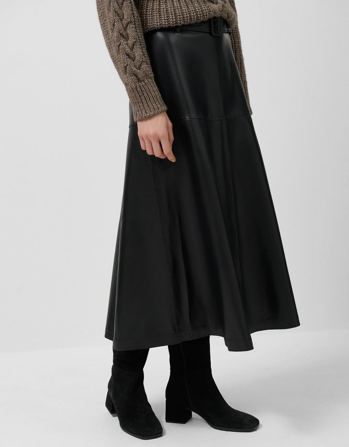 Person wearing a black skirt with a plain background