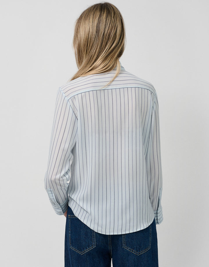 Person wearing a striped shirt and jeans on a plain background