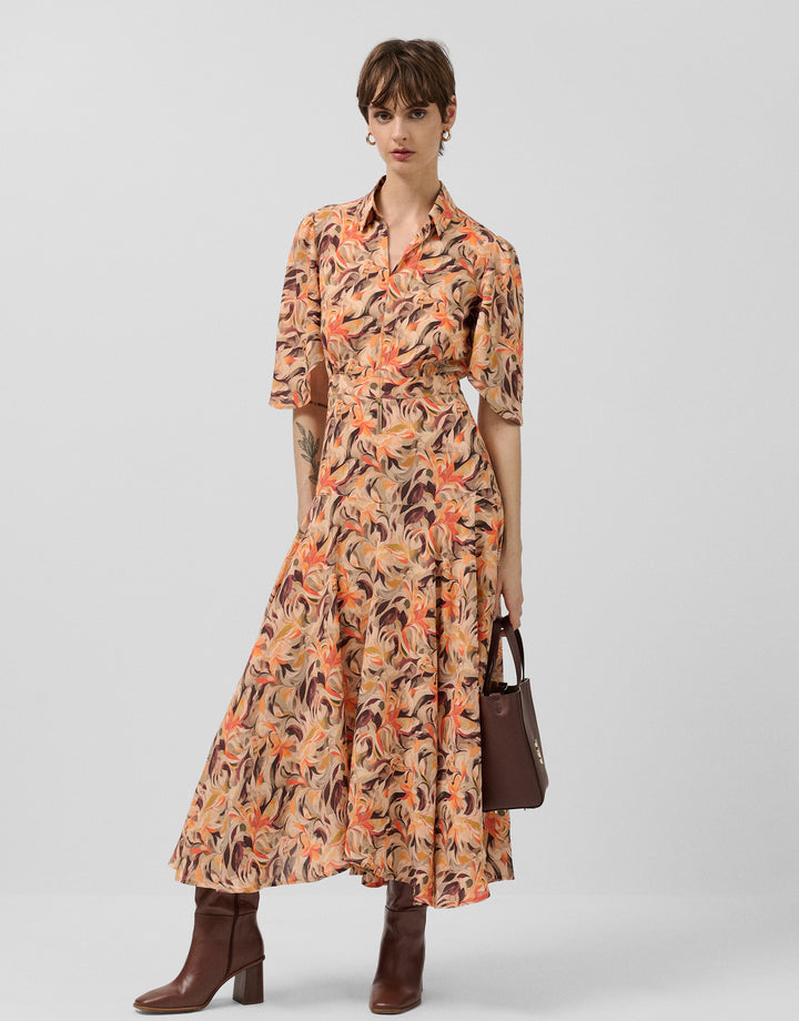 Woman wearing a patterned dress with a plain background