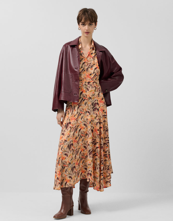 Woman wearing a floral dress with a burgundy jacket on a white background