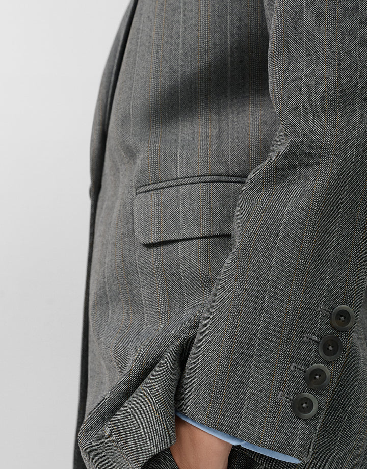 Close-up of a gray pinstripe suit jacket on a white background