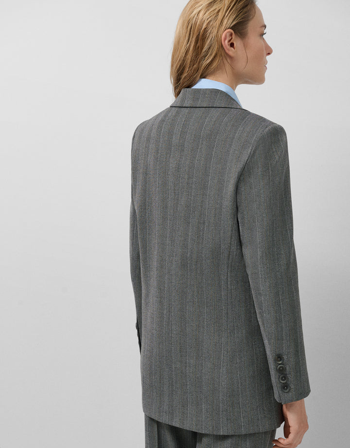 Person wearing a gray pinstripe suit on a plain background