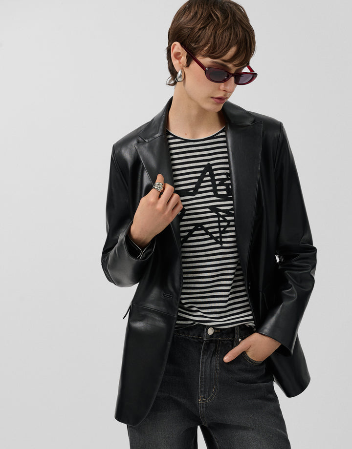 Person wearing a black leather jacket, striped shirt, and sunglasses on a light gray background