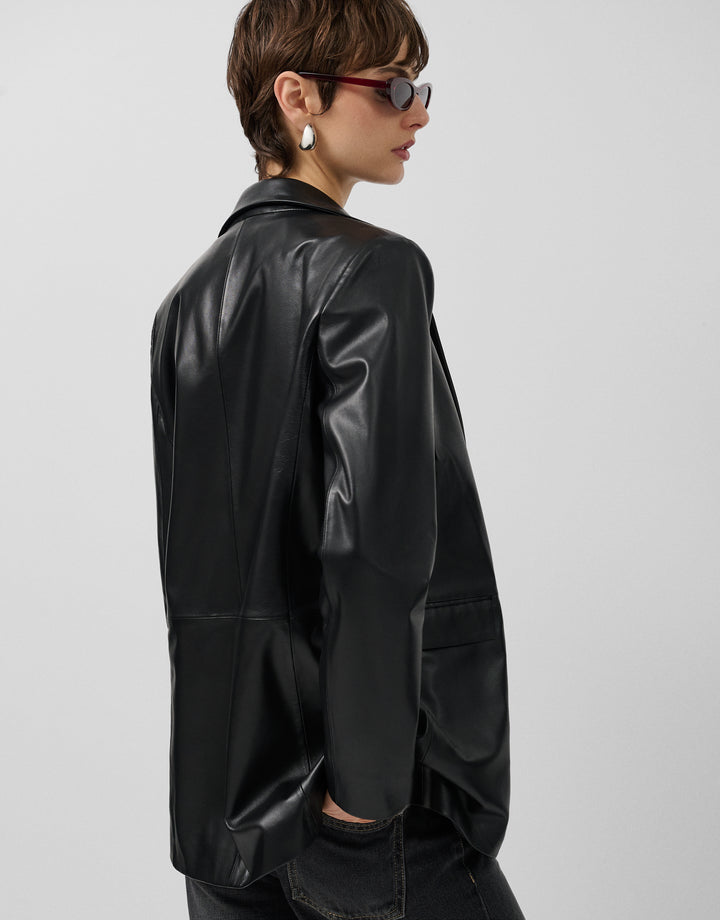 Person wearing a black leather jacket on a plain background