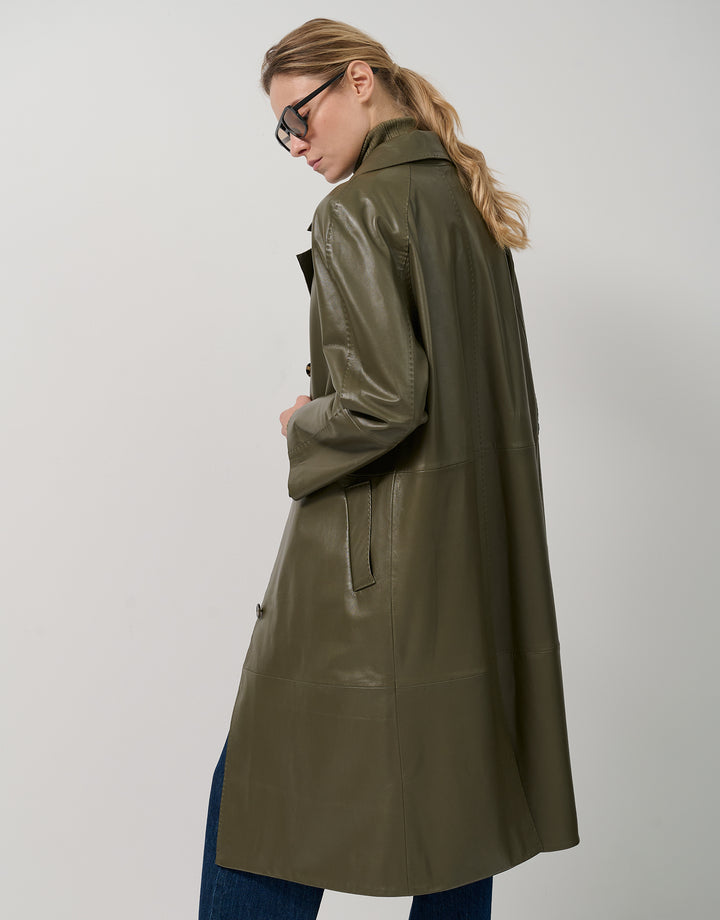 Woman wearing a green leather coat on a white background