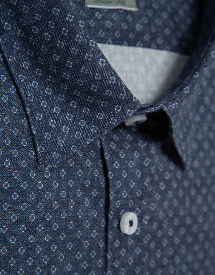 Close-up of a blue patterned shirt with a collar and button