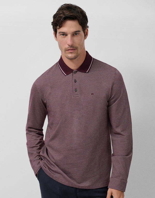 Man wearing a maroon long-sleeve polo shirt against a light gray background