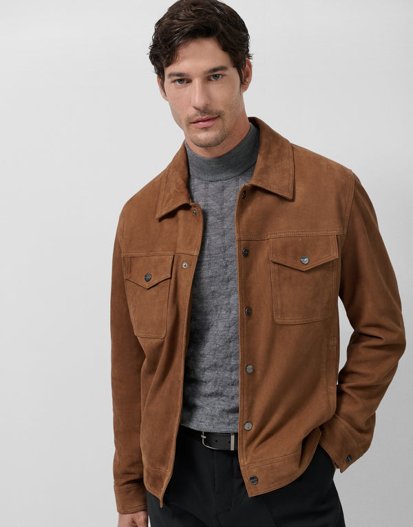 Man wearing a brown jacket over a gray sweater on a white background