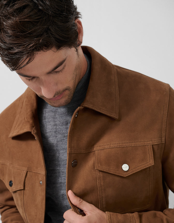 Man wearing a brown jacket with a neutral background