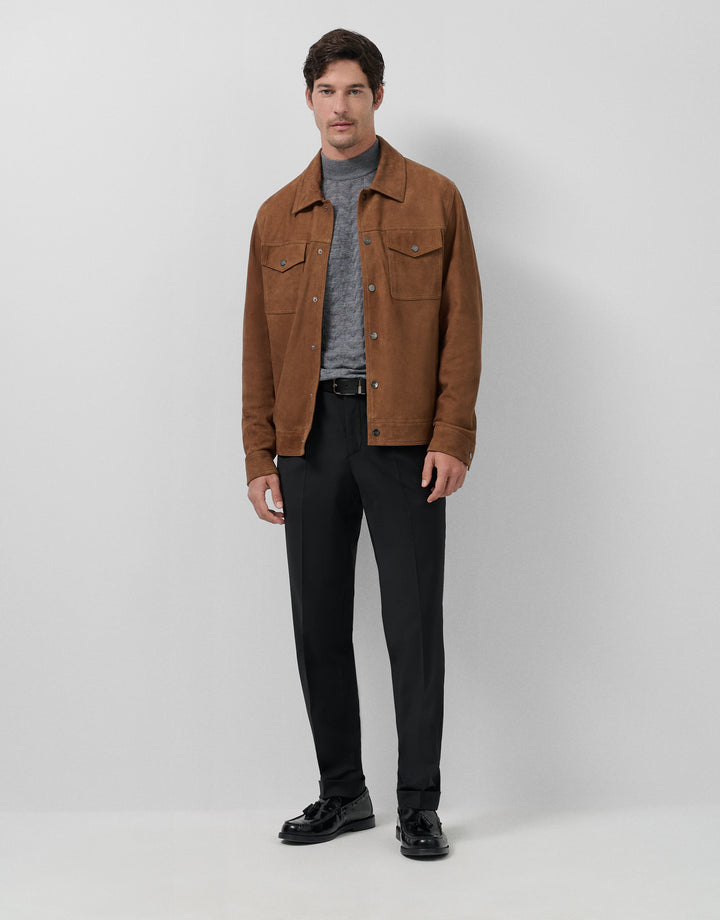 Man wearing a brown jacket, gray shirt, black pants, and black shoes on a white background