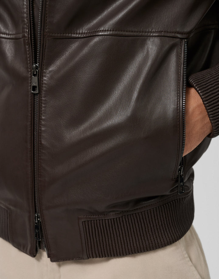 Close-up of a dark brown leather jacket with a white background