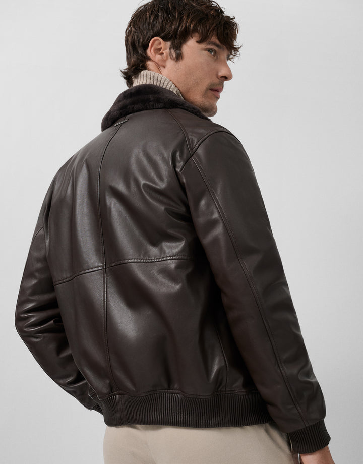 Man wearing a brown leather jacket on a plain background