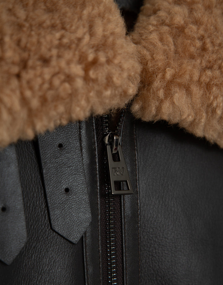 Close-up of a dark gray jacket with a zipper and brown fur collar.
