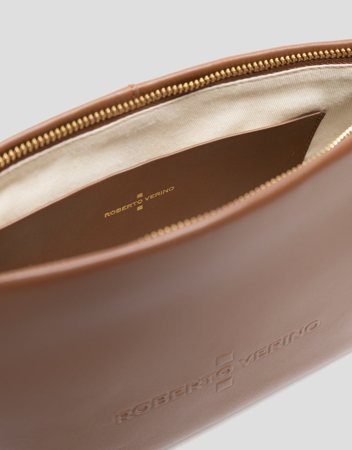 Close-up of a brown leather pouch with 'Roberto Verino' branding on a light gray background.