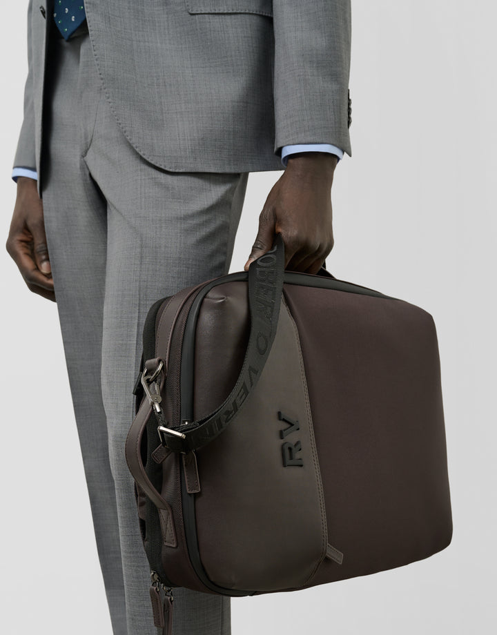 Man in gray suit holding a brown leather briefcase with 'RV' initials.