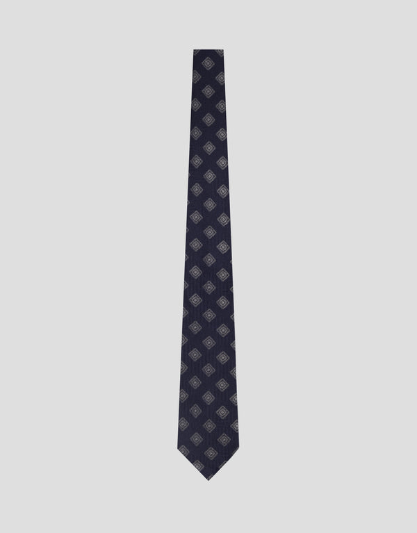 Navy blue patterned tie on a light gray background